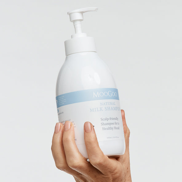 MooGoo Sensitive Scalp Milk Shampoo held in hand, sulphate-free cleanser for scalp irritation